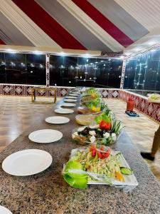 une longue table avec des assiettes de nourriture dans l'établissement Wadi Rum palace, à Wadi Rum