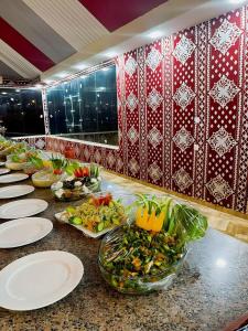 una línea de buffet con platos y tazones de comida en Wadi Rum palace, en Wadi Rum