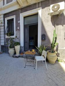 a table and a chair in front of a building at Elvira Home in Catania