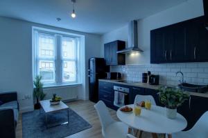 a kitchen with a white table and a white counter top at Excellent one bedroom apartment Dundee in Dundee