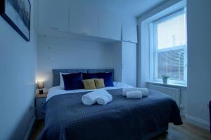 a blue bedroom with a bed with towels on it at Excellent one bedroom apartment Dundee in Dundee