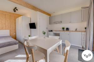 a kitchen and dining room with a white table and chairs at Ferienhaus in Pustkowo mit Eigener Terrasse in Pustkowo