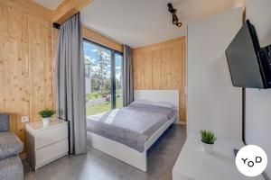 a bedroom with a bed and a large window at Ferienhaus in Pustkowo mit Eigener Terrasse in Pustkowo