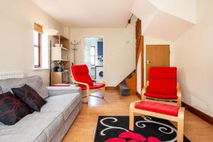 a living room with a couch and red chairs at Ferienhaus für 4 Personen ca 53 qm in Saint Columb Major, England Westküste von England in Saint Columb Major