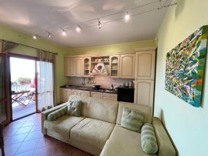 een woonkamer met een bank en een keuken bij Ferienwohnung für 4 Personen ca 40 qm in Magliano in Toscana, Toskana Maremma in Magliano in Toscana