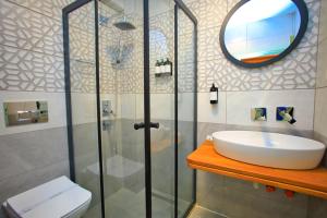 a bathroom with a sink and a shower with a mirror at west coast boutique hotel in Bodrum City