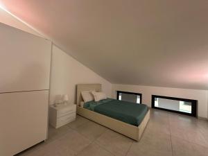 1 dormitorio con 1 cama y nevera. en Amour Içi appartamenti e suite in centro en Mascalucia