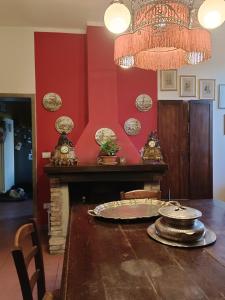 a dining room with a table and a red wall at La Maison Rouge in Crespellano