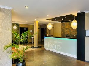 a lobby with plants and a sign in a building at Best Western Allegro Nation in Paris