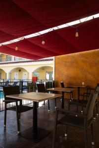 ein Restaurant mit Tischen und Stühlen und einem roten Baldachin in der Unterkunft Hotel Las Misiones in Monclova