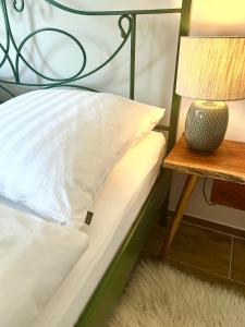 una cama con una lámpara junto a una mesa auxiliar en Großes Apartment mit Terrasse und Garten, en Oberhaching