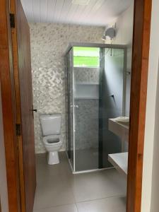 ein Bad mit einem WC, einer Dusche und einem Waschbecken in der Unterkunft Recanto Águas do Quiriri in Garuva