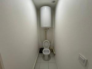 - une petite salle de bains avec toilettes dans une cabine dans l'établissement Studio PARIS-Disneyland-JO2024, à Roissy-en-Brie
