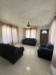 sala de estar con 2 sofás negros y techo en Cómoda Casa en Tampico a 15 min de Playa Miramar en Tampico