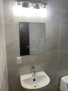 W łazience znajduje się umywalka, lustro i toaleta. w obiekcie Cómoda Casa en Tampico a 15 min de Playa Miramar w mieście Tampico