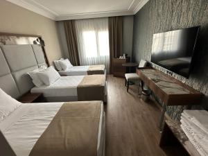 ein Hotelzimmer mit 2 Betten und einem TV in der Unterkunft The Yalı Konak Hotel İzmir in Izmir