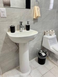 ein Badezimmer mit einem weißen Waschbecken und einem WC in der Unterkunft Cómoda Casa en Tampico a 15 min de Playa Miramar in Tampico