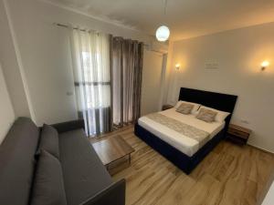 a bedroom with a bed and a couch at Julies Vila in Ksamil