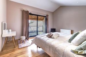 1 dormitorio con cama, escritorio y ventana en Ici on est à Laiz, en Laiz