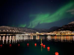 an image of the northern lights over a body of water at Le Polar Boutique in Tromsø
