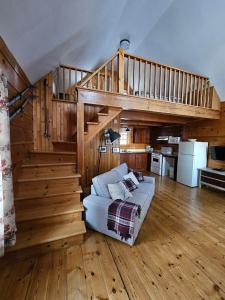 a living room with a couch and a staircase at Les Chalets sur le Cap in Saint-Joachim