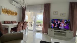 a living room with a tv and a dining table at Casa Blanca in Pag