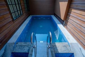 an empty swimming pool in a house with a wooden floor at The Hive, Wayanad in Wayanad