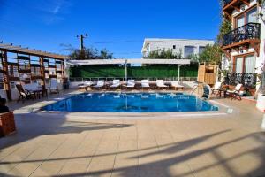 a large swimming pool with lounge chairs and a patio at west coast boutique hotel in Bodrum City