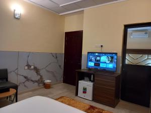 a room with a tv on a table with a bed at Holiday Homes in Ras al Khaimah