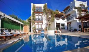 a hotel swimming pool with chairs and a building at west coast boutique hotel in Bodrum City