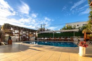 a swimming pool with chairs and a building at west coast boutique hotel in Bodrum City