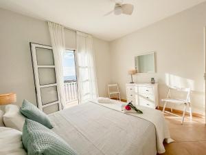 Papaya Apartments Boa Vista في سال ري: غرفة نوم بيضاء بها سرير ونافذة