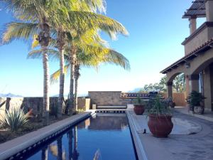 una piscina con palmeras junto a un edificio en Casa de Vista Hermosa, en Loreto