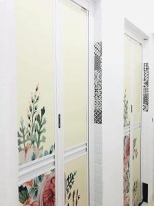 een badkamer met een glazen deur met bloemenbehang bij Lovely Jannah Cottage Kulim in Kulim