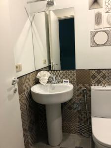 ein Badezimmer mit einem Waschbecken, einem Spiegel und einem WC in der Unterkunft Hotel In City in Yerevan