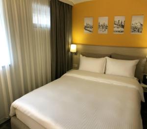 1 cama blanca grande en una habitación con ventana en Hotel In City, en Ereván
