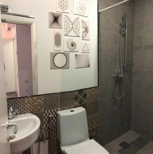 ein Badezimmer mit einem WC, einem Waschbecken und einem Spiegel in der Unterkunft Hotel In City in Yerevan