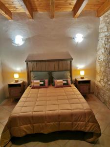 una camera da letto con un grande letto con due comodini di Gîte du Gros Chêne en Périgord a Cavarc