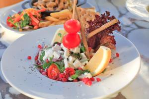 a plate of food with a salad and a lemon slice at west coast boutique hotel in Bodrum City