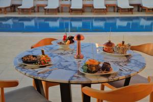 a table with plates of food on it next to a pool at west coast boutique hotel in Bodrum City