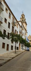 un grand bâtiment blanc avec un arbre devant dans l'établissement Habitation suite Pego, vue mer 15 mn de Denia 10 mn de la plage, à Pego