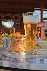 a glass of beer sitting next to a bowl of food at west coast boutique hotel in Bodrum City
