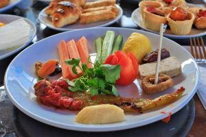 a plate of food with vegetables on a table at west coast boutique hotel in Bodrum City