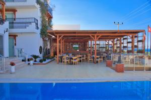 a wooden pavilion with tables and chairs next to a building at west coast boutique hotel in Bodrum City
