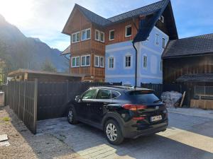 ein schwarzes Auto, das vor einem Haus parkt in der Unterkunft Holiday Home Doris in Bad Goisern