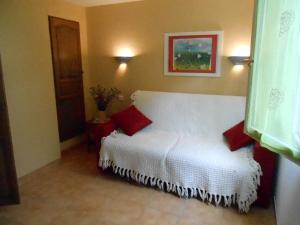 a bedroom with a white bed with red pillows at Les Soleillas pour votre zen'ittude in Chalencon