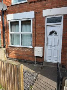 a brick house with a white door and a window at Spacious 2-Bed House in Newark in Newark-on-Trent