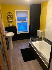a bathroom with a tub and a toilet and a sink at Spacious 2-Bed House in Newark in Newark-on-Trent