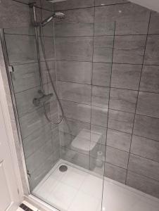 a shower with a glass door with a toilet at Spacious 2-Bed House in Newark in Newark-on-Trent