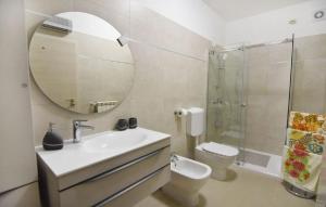 ein Badezimmer mit Waschbecken, Toilette und Spiegel in der Unterkunft Komfortable Wohnung in Savudrija mit Grill, Garten und Terrasse in Savudrija